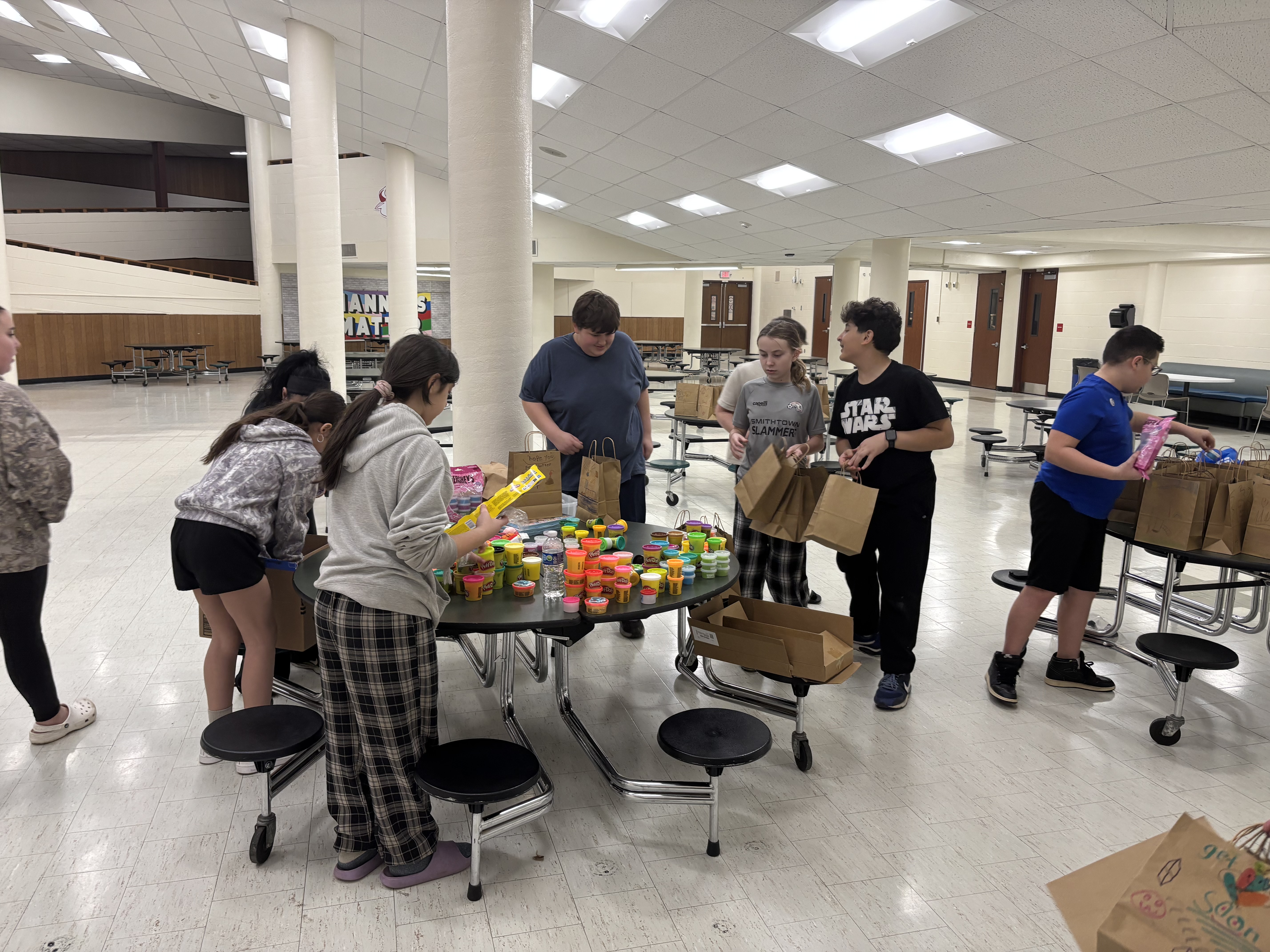 Builders Club packing bags in the school cafeteria